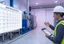 Maintenance manager building a preventive maintenance program with an asset list and schedule on a facility floor