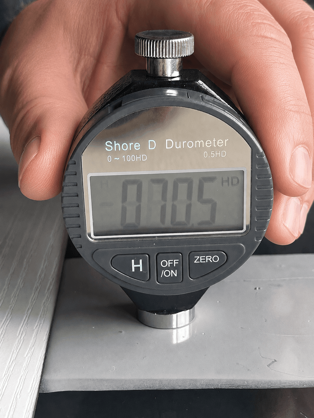 Step #3: Press the bottom probe flat against a samples coating - The device must be fully flat against the coating.