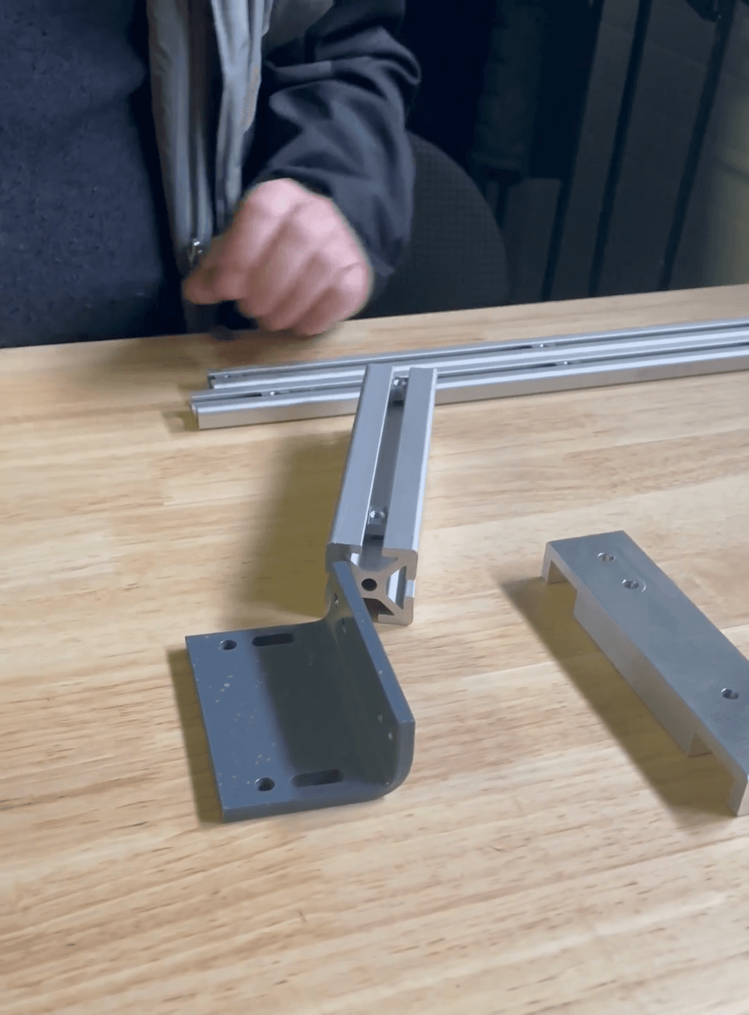 Step #4: Mount the L bracket onto the larger rail. Place the L-bracket on top of the larger rail.Insert a T-nut into the rail's channel through the first slot of the L-bracket.Insert the second T-nut into the other channel through the second slot of the L-bracket.